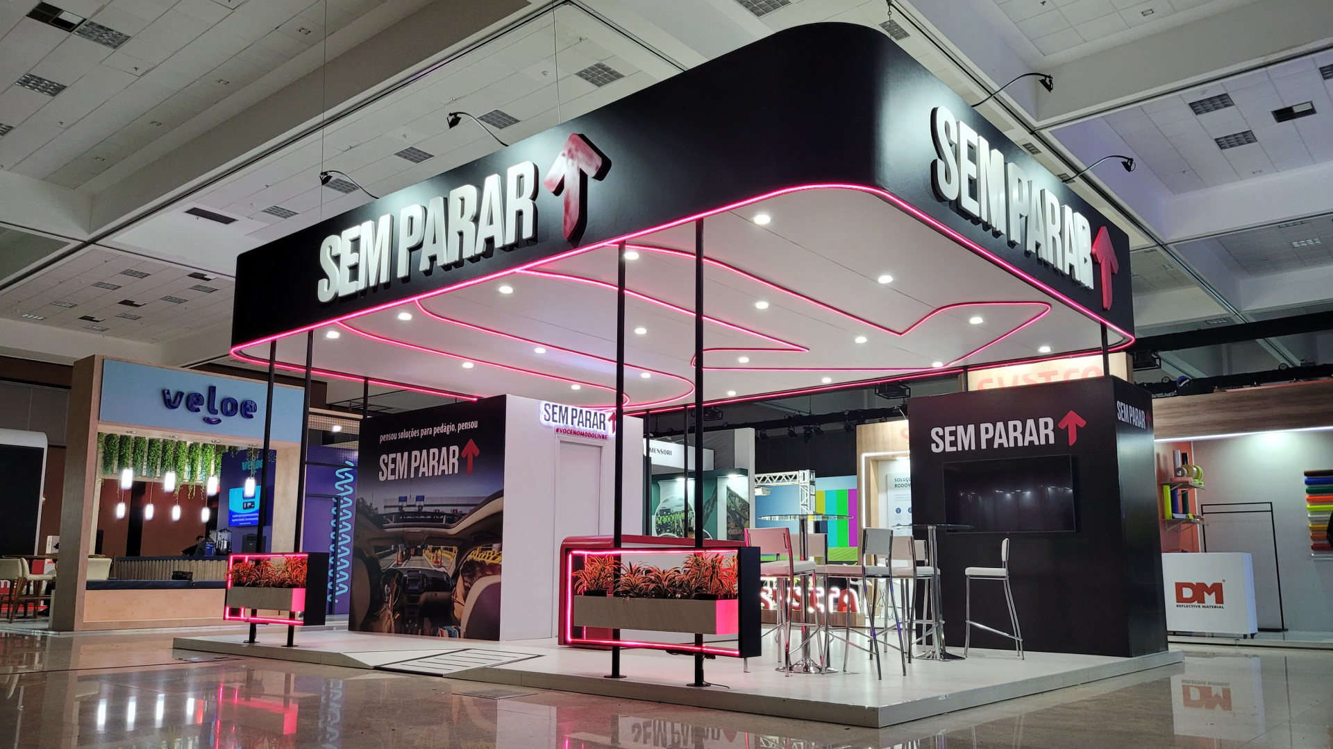 Estande Sem Parar com iluminação em rosa neon